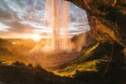 A photograph taken behind Seljalandsfoss waterfall in South Iceland