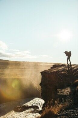 A photographer at a waterfall in Iceland